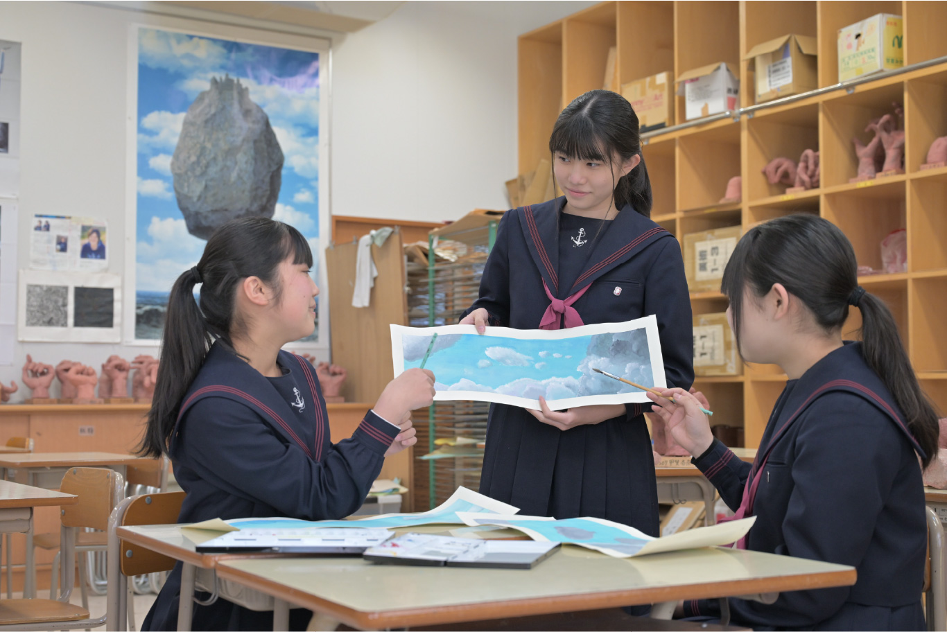 美術室で作品を見せ合う生徒たち